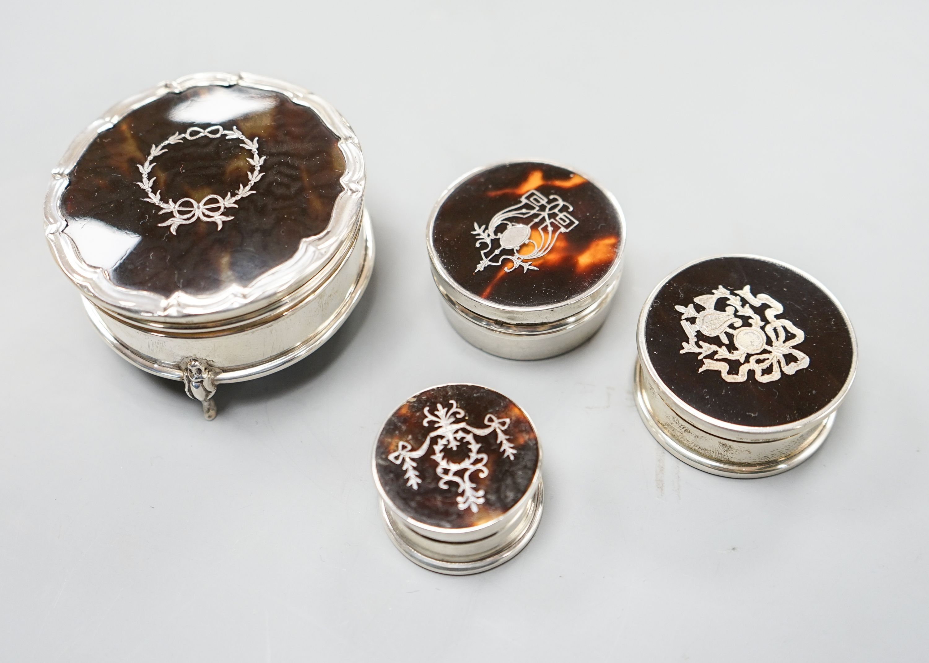 A George V silver and tortoiseshell pique circular trinket box, Birmingham, 1923, 61mm and three other similar smaller boxes and covers.